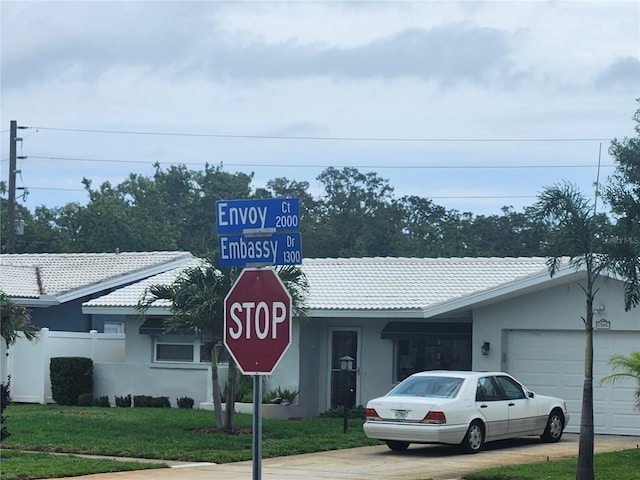 exterior view of stucco siding, a tiled roof, and concrete driveway