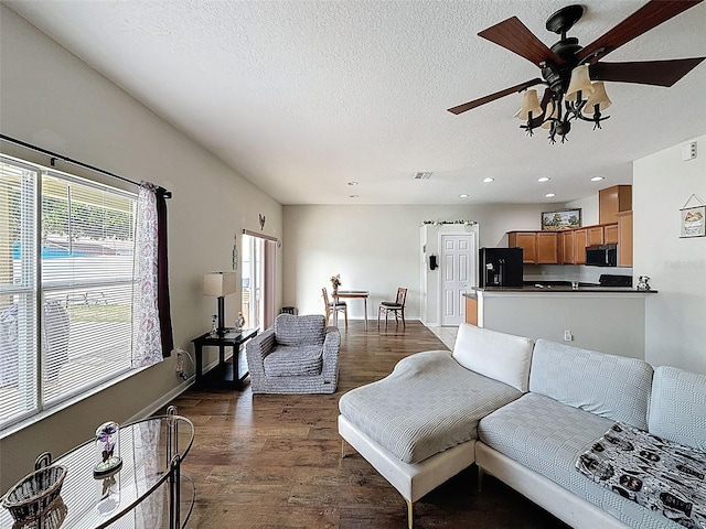 living room featuring recessed lighting, a textured ceiling, a ceiling fan, dark wood-style flooring, and baseboards