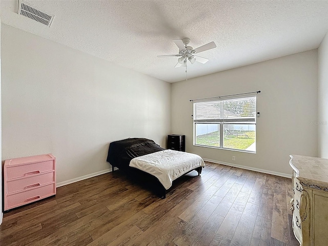 bedroom with dark wood-style flooring, baseboards, a textured ceiling, and ceiling fan
