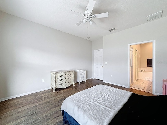 bedroom featuring wood finished floors, baseboards, ensuite bathroom, and ceiling fan