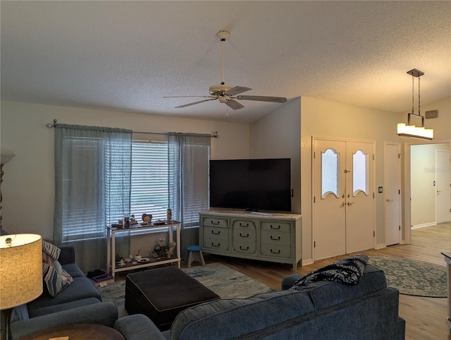 living area with wood finished floors, ceiling fan, and a textured ceiling