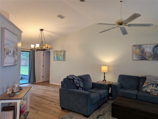 living room featuring lofted ceiling, a chandelier, wood finished floors, a ceiling fan, and baseboards