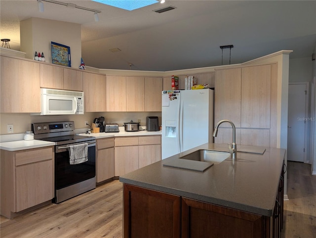 kitchen featuring white appliances, light brown cabinets, a sink, light wood-style flooring, and track lighting