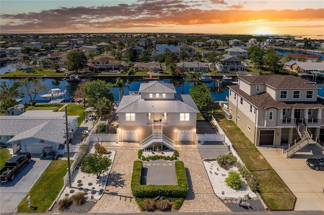 aerial view at dusk of a water view and a residential view