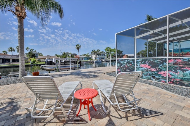 view of patio featuring a water view, a dock, and a lanai