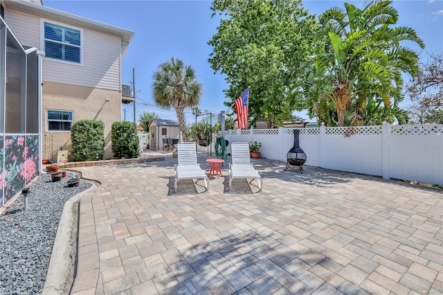 view of patio with a storage unit, an outdoor structure, and a fenced backyard