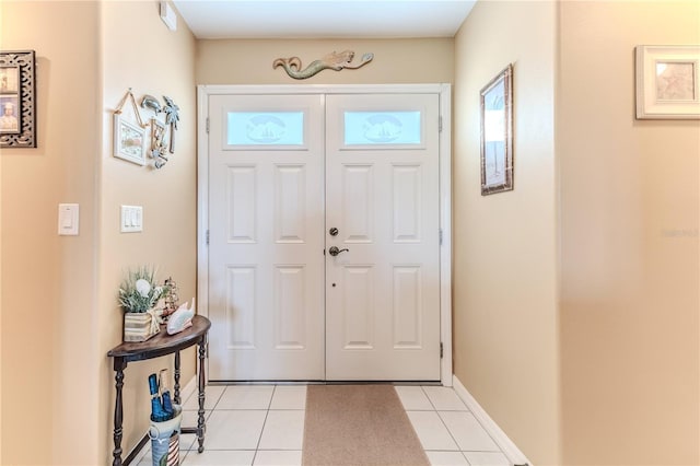 entryway featuring light tile patterned floors, healthy amount of natural light, and baseboards