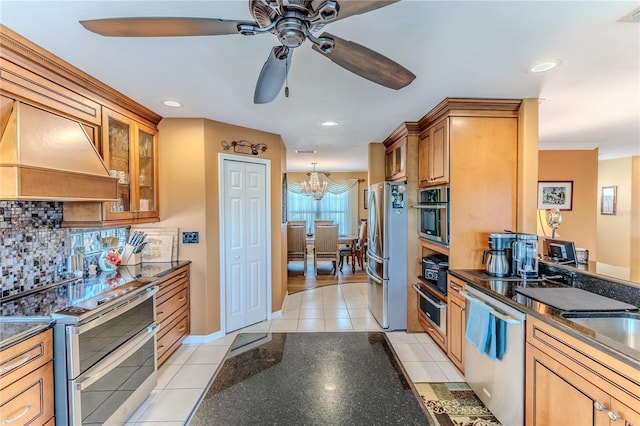 kitchen with stainless steel appliances, dark countertops, light tile patterned flooring, a ceiling fan, and decorative backsplash