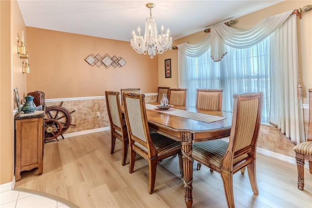 dining space with a chandelier, light wood-style floors, and baseboards