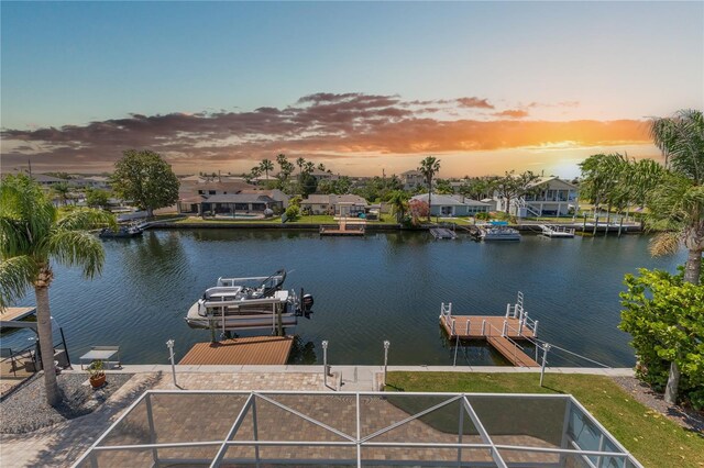 dock featuring a water view, boat lift, and a residential view