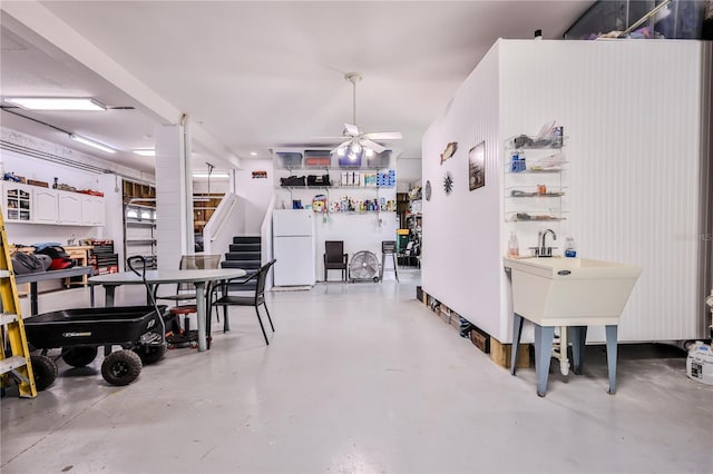 dining area featuring concrete flooring, ceiling fan, and stairs