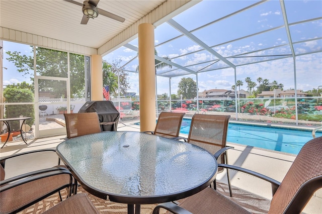 sunroom / solarium featuring ceiling fan, healthy amount of natural light, and outdoor dining space