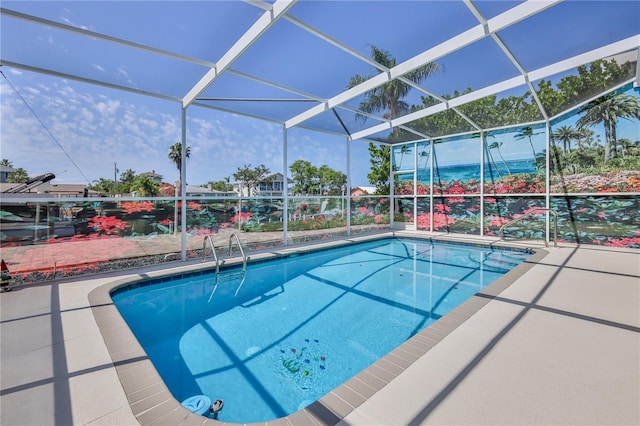 outdoor pool with glass enclosure and a patio area
