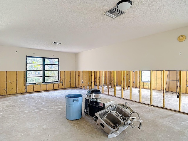 4420 Marine Pkwy, New Port Richey, FL 34652 - miscellaneous room featuring a textured ceiling, a wainscoted wall, wood walls, and unfinished concrete flooring