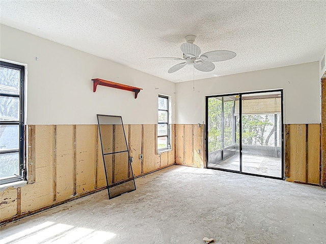 4420 Marine Pkwy, New Port Richey, FL 34652 - unfurnished room with a wainscoted wall, a ceiling fan, a textured ceiling, and wood walls