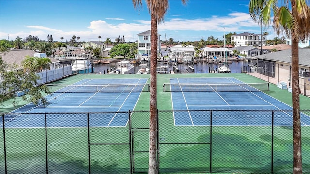 4420 Marine Pkwy, New Port Richey, FL 34652 - view of tennis court featuring fence, a residential view, and a water view
