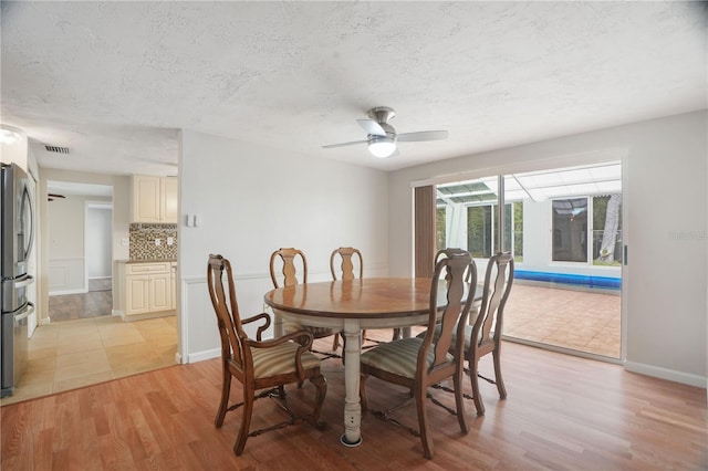 12106 Bear Creek Ln, Hudson, FL 34667 - dining space with ceiling fan, light wood finished floors, a textured ceiling, and baseboards