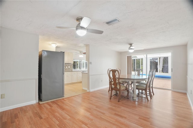 12106 Bear Creek Ln, Hudson, FL 34667 - dining room with light wood-type flooring, ceiling fan, and a textured ceiling