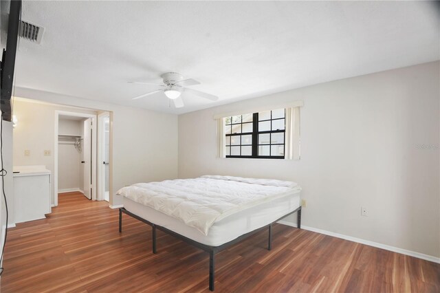 12106 Bear Creek Ln, Hudson, FL 34667 - bedroom with wood finished floors, baseboards, a closet, and a walk in closet