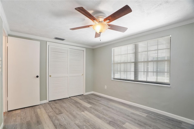 12106 Bear Creek Ln, Hudson, FL 34667 - unfurnished bedroom featuring wood finished floors, crown molding, a closet, baseboards, and a ceiling fan