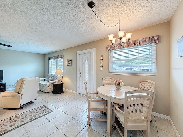 11821 Boynton Ln, New Port Richey, FL 34654 - dining space with a chandelier, light tile patterned floors, a textured ceiling, and baseboards