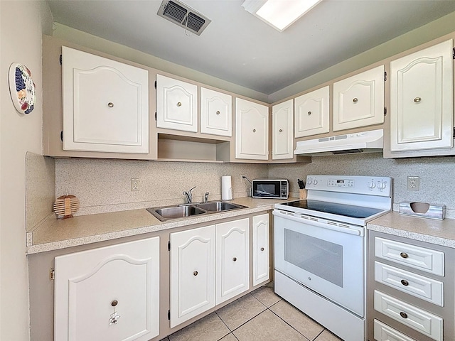 11821 Boynton Ln, New Port Richey, FL 34654 - kitchen featuring white range with electric cooktop, under cabinet range hood, a sink, light tile patterned floors, and decorative backsplash