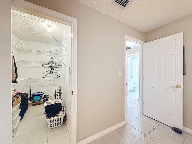 11821 Boynton Ln, New Port Richey, FL 34654 - hall featuring a textured ceiling, light tile patterned floors, and baseboards