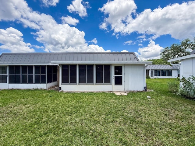 11821 Boynton Ln, New Port Richey, FL 34654 - rear view of house with a sunroom, a standing seam roof, a yard, and metal roof