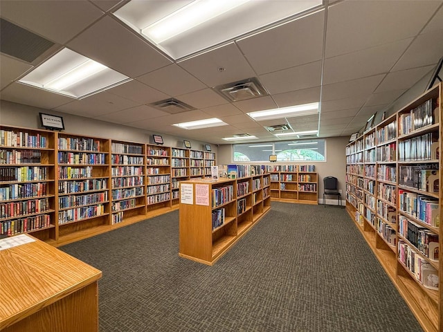 11821 Boynton Ln, New Port Richey, FL 34654 - office featuring bookshelves, dark colored carpet, and a drop ceiling