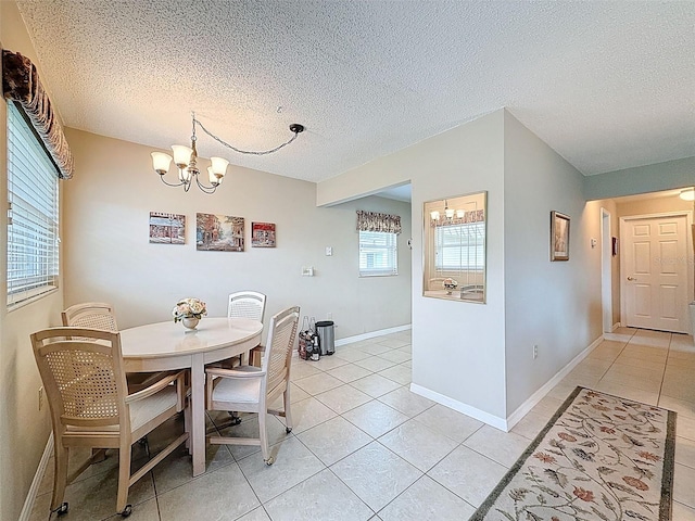 11821 Boynton Ln, New Port Richey, FL 34654 - dining room featuring a chandelier, light tile patterned flooring, a textured ceiling, and baseboards