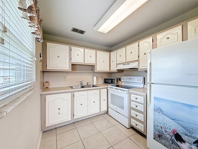 11821 Boynton Ln, New Port Richey, FL 34654 - kitchen featuring white appliances, under cabinet range hood, light tile patterned flooring, a sink, and white cabinetry