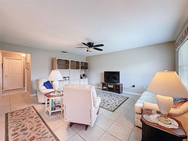 11821 Boynton Ln, New Port Richey, FL 34654 - living room featuring light tile patterned floors, ceiling fan, baseboards, and a textured ceiling