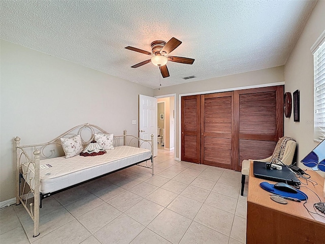 11821 Boynton Ln, New Port Richey, FL 34654 - bedroom featuring a closet, a textured ceiling, light tile patterned flooring, and a ceiling fan