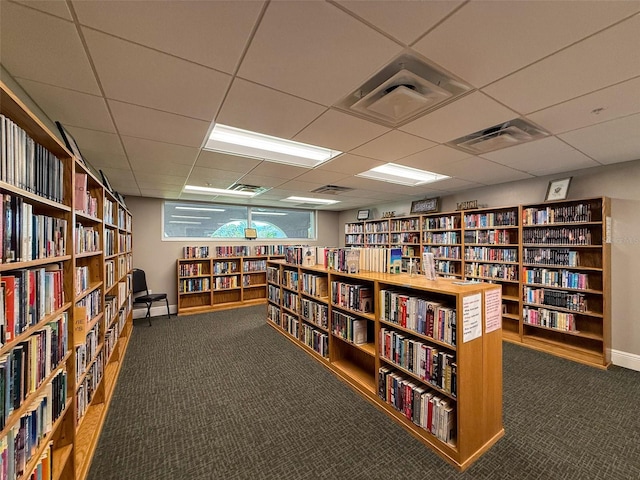 11821 Boynton Ln, New Port Richey, FL 34654 - miscellaneous room with wall of books, carpet flooring, a paneled ceiling, and baseboards