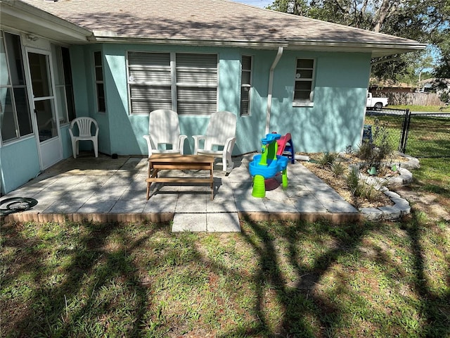 2158 Clayton Ave, Spring Hill, FL 34609 - rear view of house featuring roof with shingles, a patio area, and stucco siding