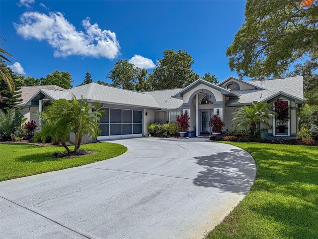 13627 Glaze Brook Dr, Hudson, FL 34667 - ranch-style house featuring curved driveway, a front yard, and stucco siding