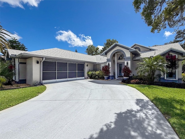13627 Glaze Brook Dr, Hudson, FL 34667 - ranch-style house with a garage, stucco siding, concrete driveway, a front lawn, and roof with shingles