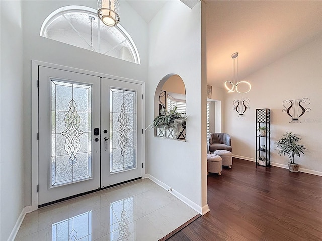 13627 Glaze Brook Dr, Hudson, FL 34667 - entryway with french doors, baseboards, a chandelier, high vaulted ceiling, and wood finished floors