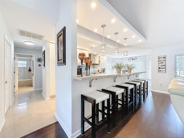 13627 Glaze Brook Dr, Hudson, FL 34667 - kitchen featuring a breakfast bar, baseboards, recessed lighting, a peninsula, and healthy amount of natural light