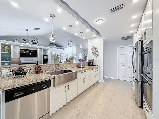 13627 Glaze Brook Dr, Hudson, FL 34667 - kitchen with stainless steel appliances, a sink, hanging light fixtures, vaulted ceiling, and white cabinetry