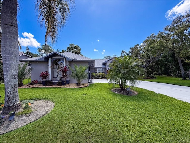 13627 Glaze Brook Dr, Hudson, FL 34667 - view of front of house with stucco siding, a front lawn, and driveway