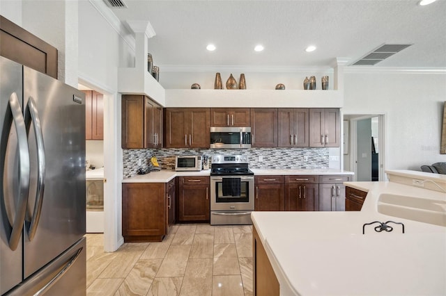 kitchen with stainless steel appliances, ornamental molding, backsplash, a sink, and light countertops