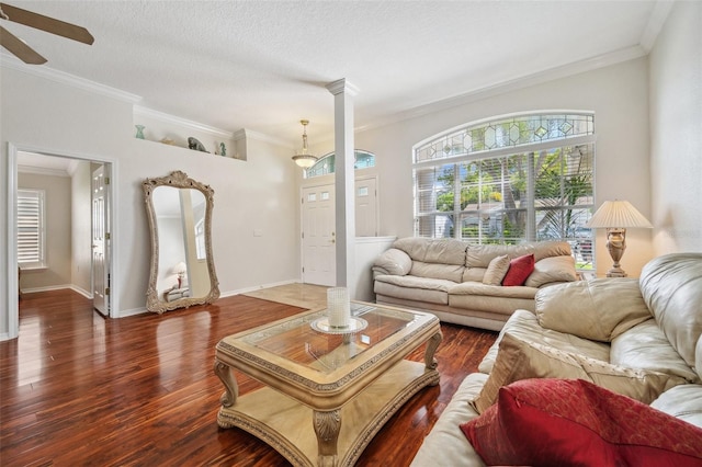 living room with wood finished floors, ceiling fan, crown molding, decorative columns, and baseboards
