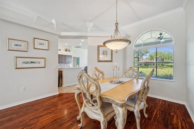dining room featuring light wood finished floors, baseboards, and ornamental molding