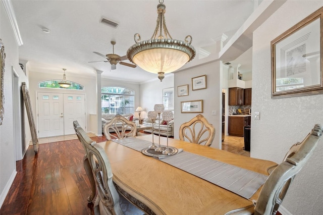 dining space featuring wood finished floors, ceiling fan, crown molding, and baseboards