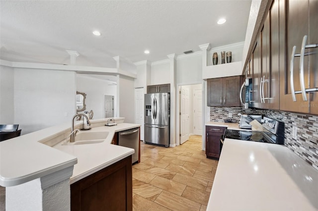 kitchen featuring appliances with stainless steel finishes, a sink, tasteful backsplash, ornamental molding, and light countertops