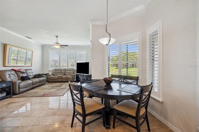 dining room with healthy amount of natural light, crown molding, ceiling fan, and baseboards
