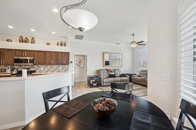 dining space with a ceiling fan, crown molding, and recessed lighting