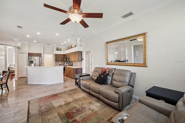 living area with crown molding, a ceiling fan, ornate columns, and recessed lighting