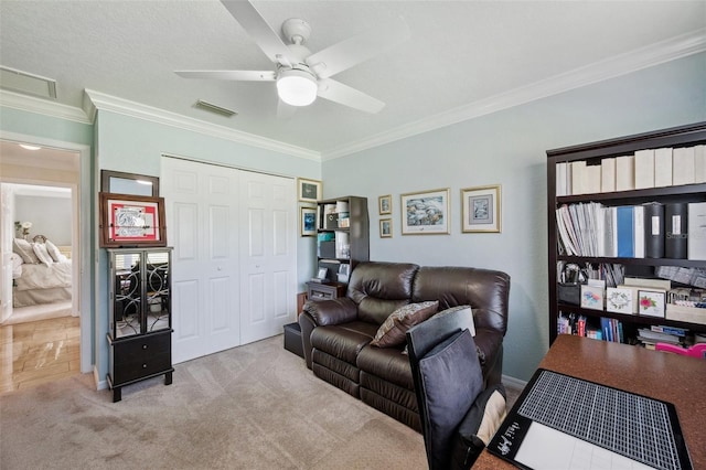 living area with ornamental molding, carpet flooring, and ceiling fan